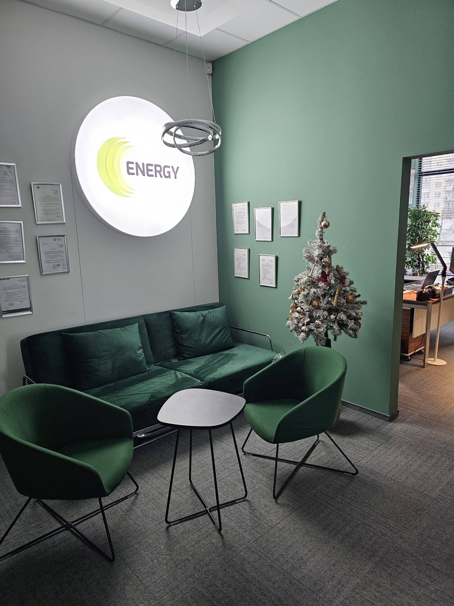 Recepcja biura firmy Energy z podświetlanym logo i certyfikatami na ścianie