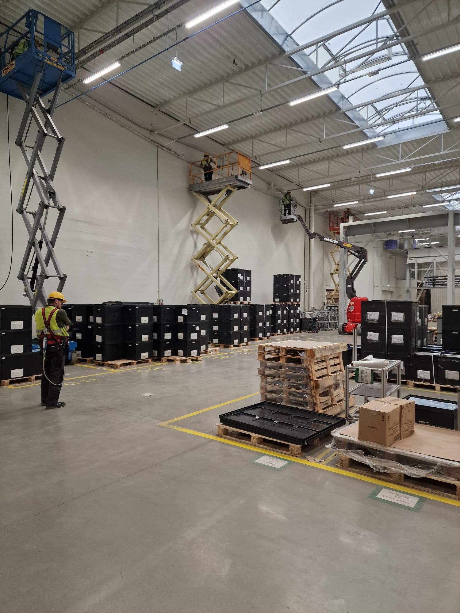 Montaż instalacji elektrycznych w hali z użyciem podnośników nożycowych